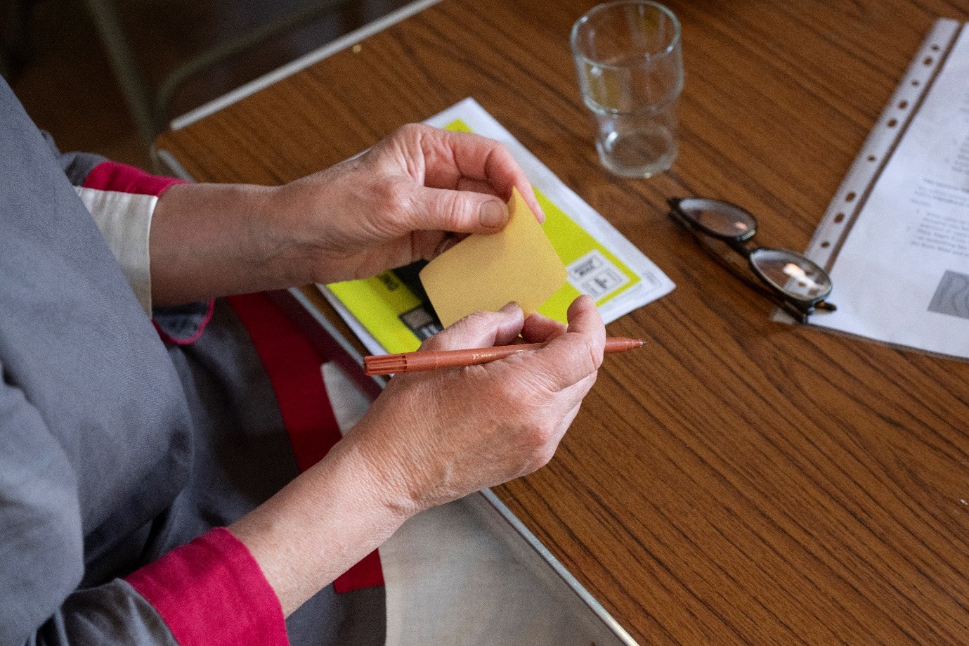 Participant holding memo note and pen about to write thoughts